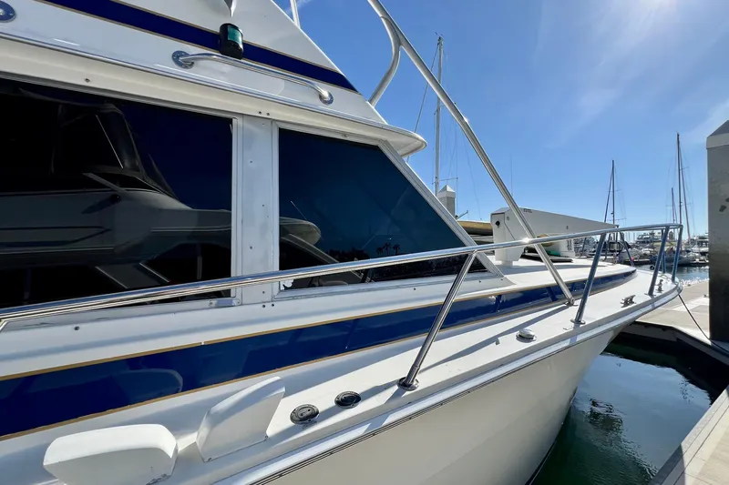 Slide: The Image of 1982 Bertram 46 Convertible yacht docked at marina under clear blue sky. - 18