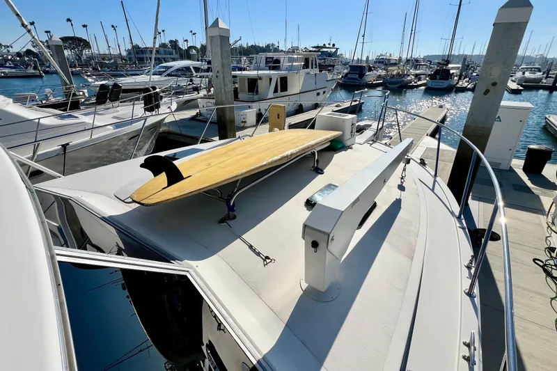 Slide: The Image of 1982 Bertram 46 Convertible yacht with surfboard on deck, docked at marina. - 20