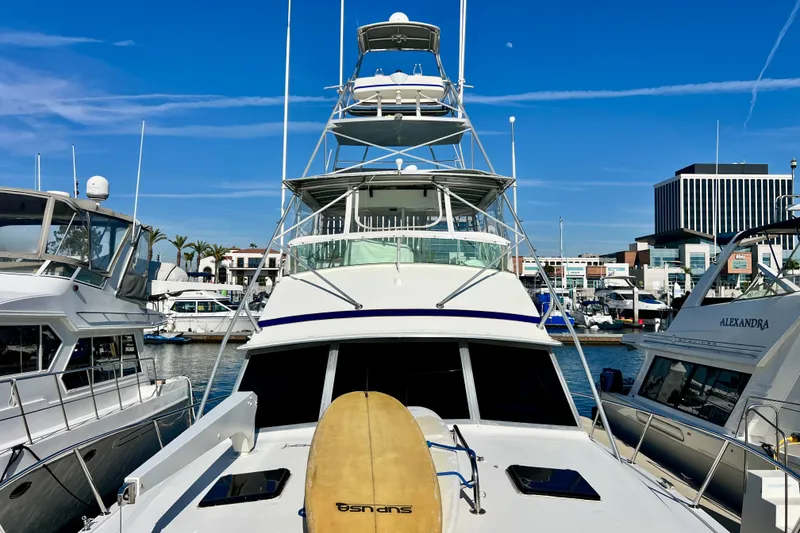 Slide: The Image of 1982 Bertram 46 Convertible yacht docked at marina, clear blue sky background. - 25