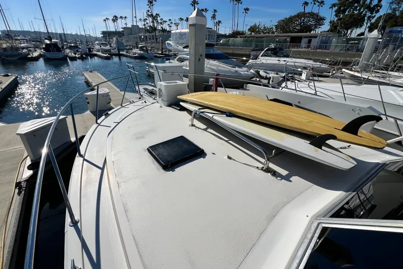 Slide: The Image of 1982 Bertram 46 Convertible yacht with surfboards on deck, docked in a sunny marina. - 26