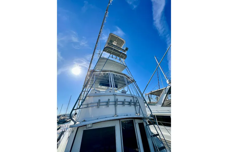 Slide: The Image of 1982 Bertram 46 Convertible yacht under clear blue sky, showcasing its structure and design. - 27