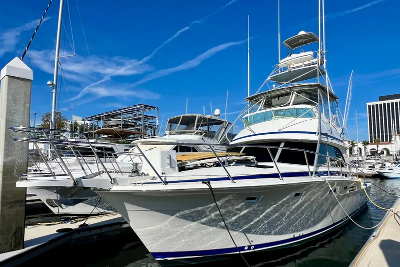 Slide: The Image of 1982 Bertram 46 Convertible yacht docked at marina under clear blue sky. - 3