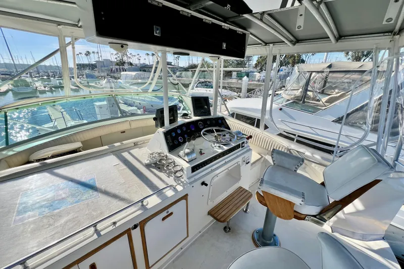 Slide: The Image of Interior view of 1982 Bertram 46 Convertible yacht helm with marina background. - 38