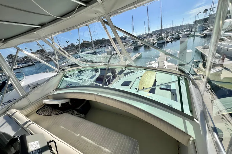 Slide: The Image of 1982 Bertram 46 Convertible yacht interior with marina view, showcasing luxury seating and clear windows. - 47