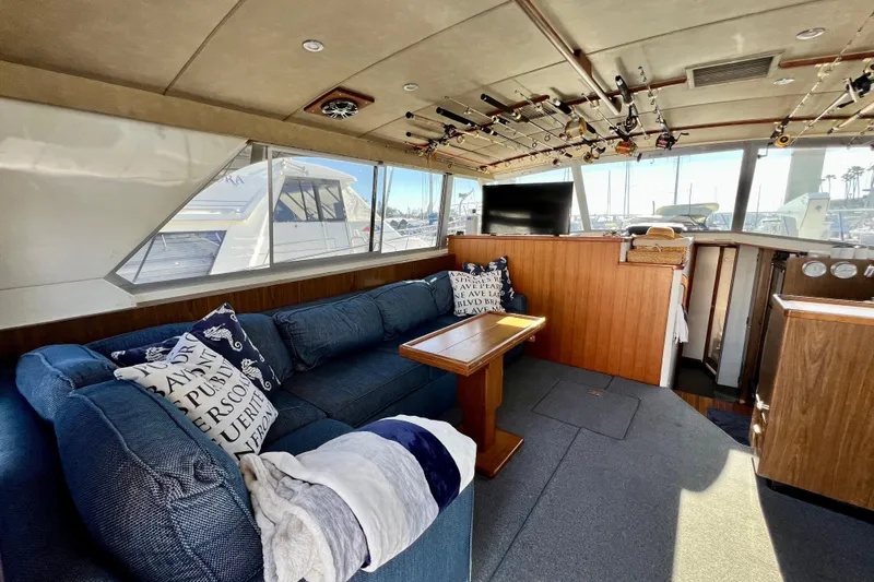 Slide: The Image of Interior of 1982 Bertram 46 Convertible yacht with cozy seating and fishing rods. - 50