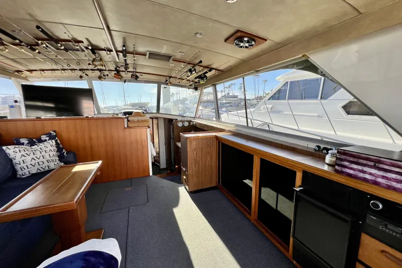 Slide: The Image of Interior of 1982 Bertram 46 Convertible yacht with fishing rods and cozy seating area. - 51
