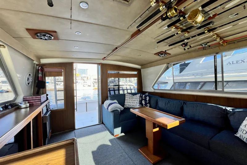 Slide: The Image of Interior of 1982 Bertram 46 Convertible yacht with fishing rods and cozy seating area. - 52