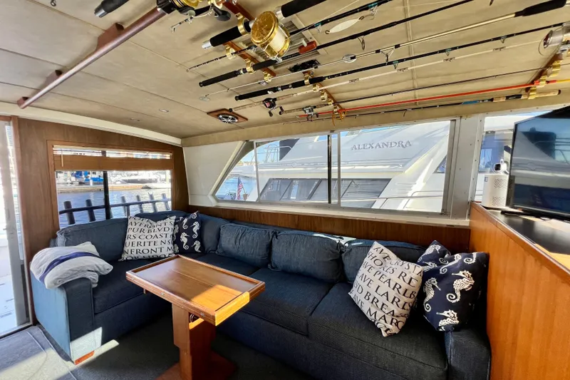 Slide: The Image of Interior of 1982 Bertram 46 Convertible yacht with fishing rods and cozy seating area. - 53