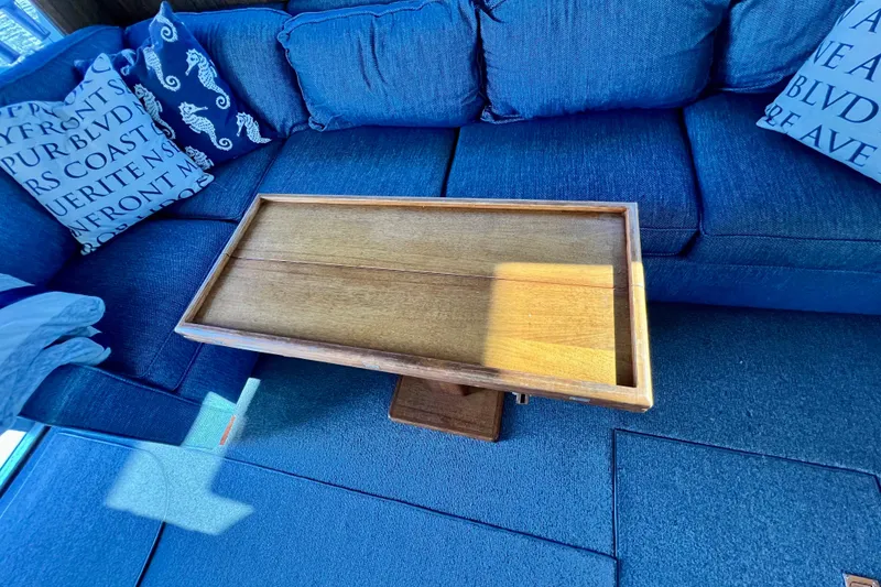 Slide: The Image of Wooden table on a blue sofa in a 1982 Bertram 46 Convertible yacht interior. - 54