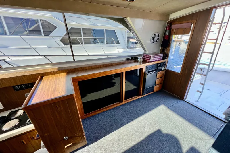 Slide: The Image of Interior of 1982 Bertram 46 Convertible yacht with wood cabinetry and large windows. - 56