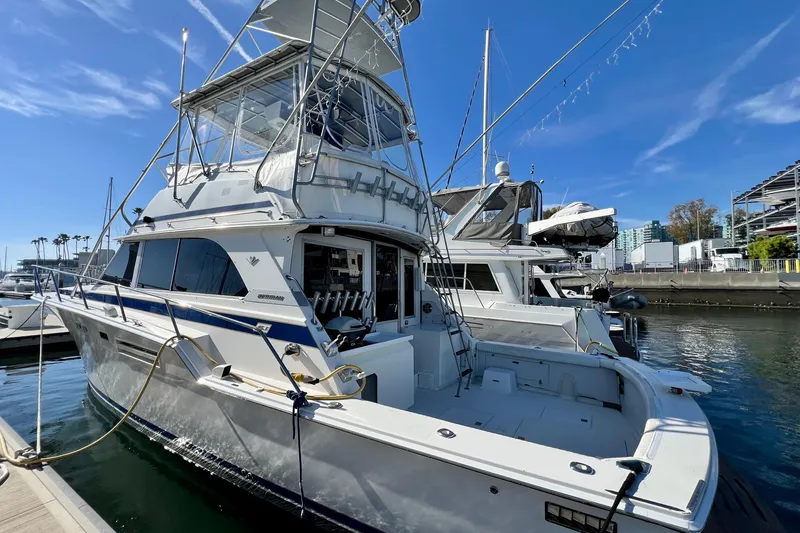 Slide: The Image of 1982 Bertram 46 Convertible yacht docked in marina under clear blue sky. - 6