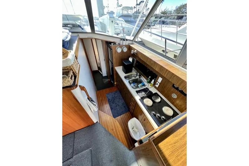 Slide: The Image of Interior of 1982 Bertram 46 Convertible yacht, featuring compact kitchen with stove and sink. - 60