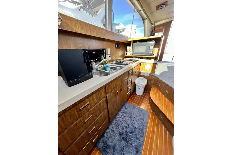 Slide: The Image of Interior of 1982 Bertram 46 Convertible yacht kitchen with wood cabinetry and modern appliances. - 62