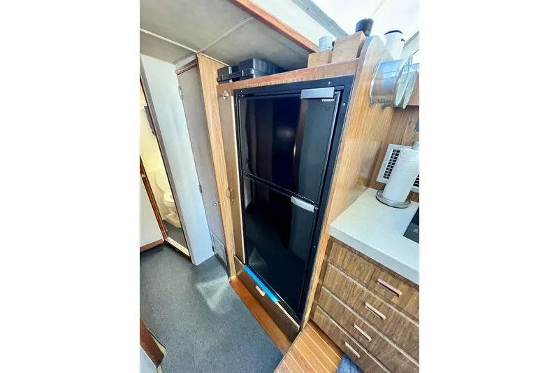 Slide: The Image of Interior of 1982 Bertram 46 Convertible yacht featuring a compact kitchen area. - 63