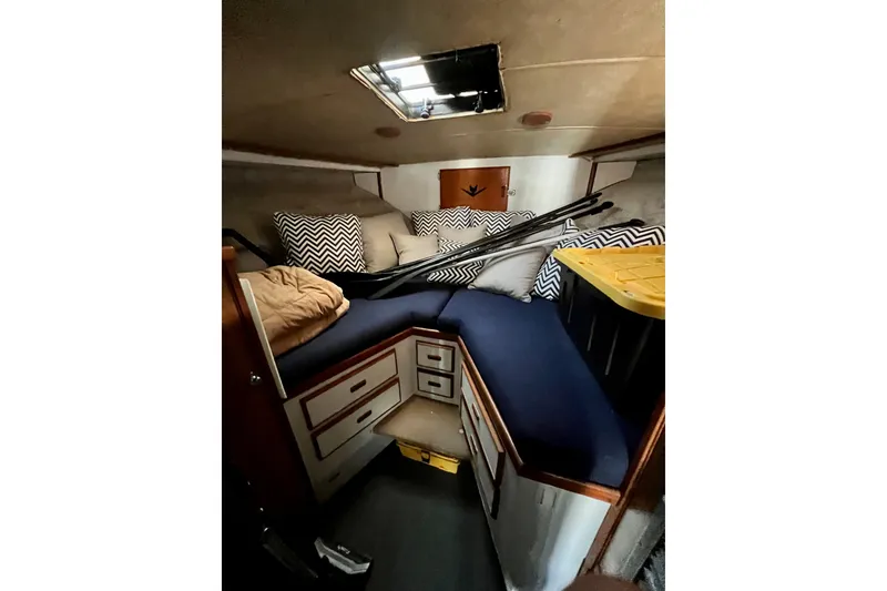 Slide: The Image of 1982 Bertram 46 Convertible cabin interior with cushions and storage. - 68