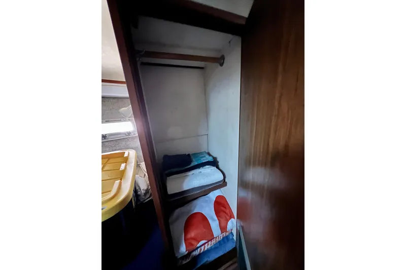 Slide: The Image of Interior of 1982 Bertram 46 Convertible yacht with storage shelves and towels. - 69