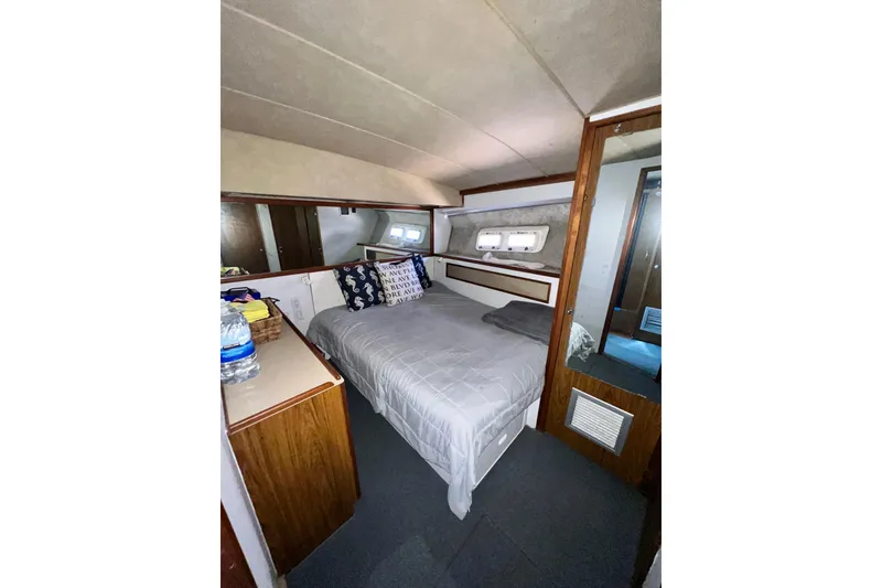 Slide: The Image of 1982 Bertram 46 Convertible cabin interior with bed, wooden cabinetry, and nautical decor. - 71