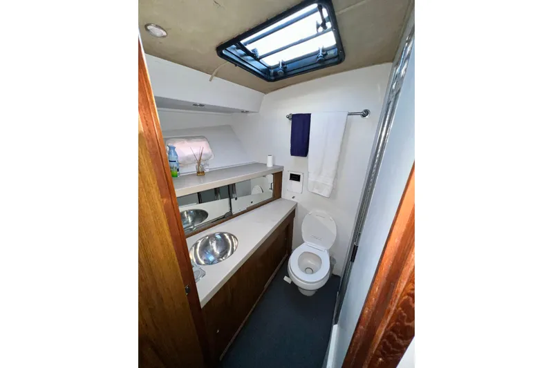 Slide: The Image of Bathroom interior of 1982 Bertram 46 Convertible yacht, featuring sink, toilet, and skylight. - 74