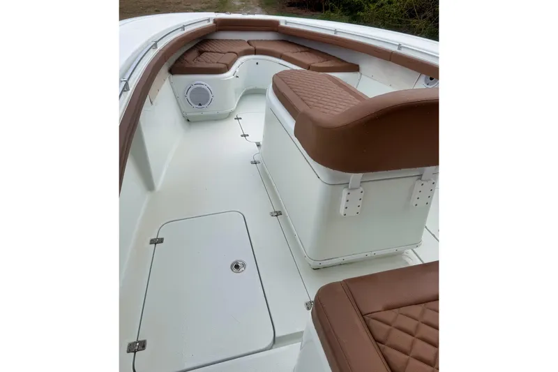 Slide: The Image of 2018 Yellowfin 36 Offshore boat with brown quilted seating, lush greenery in background. - 2