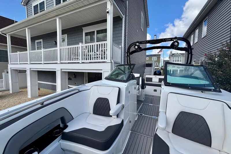 Slide: The Image of 2021 Monterey M-65 boat docked near modern coastal homes under a blue sky. - 12