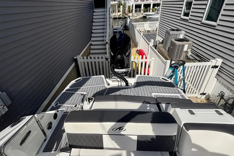 Slide: The Image of 2021 Monterey M-65 boat docked between houses, featuring sleek design and modern outboard motor. - 15