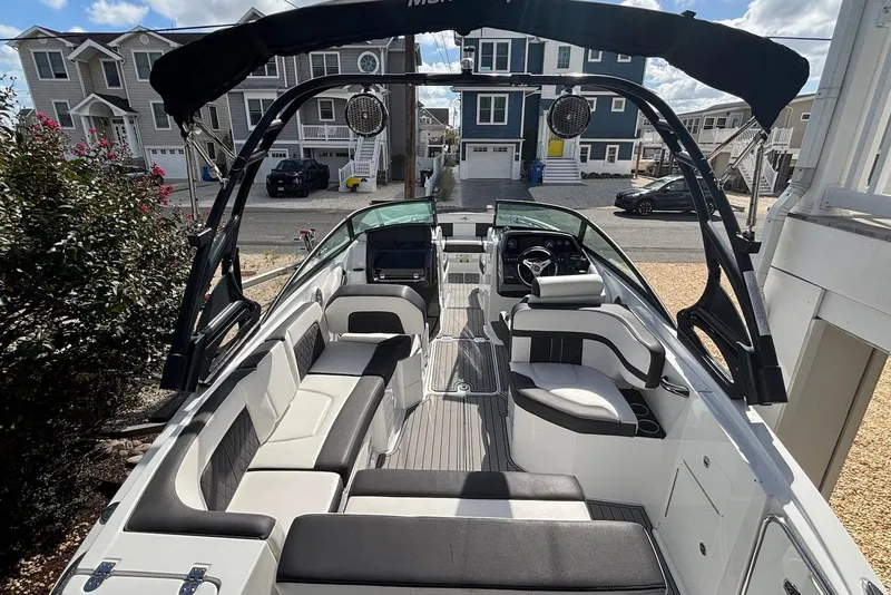 Slide: The Image of 2021 Monterey M-65 boat interior with sleek seating and modern design, parked near residential area. - 3
