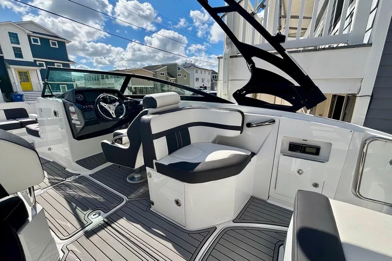 Slide: The Image of 2021 Monterey M-65 boat interior with modern seating and steering, under a partly cloudy sky. - 7