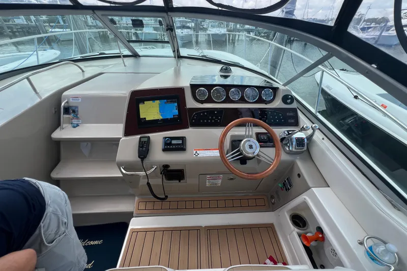 Slide: The Image of 2005 Sea Ray Sundancer 350 helm with navigation system and wooden steering wheel. - 11