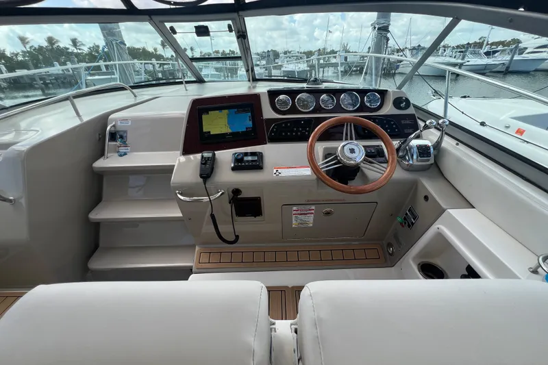 Slide: The Image of 2005 Sea Ray Sundancer 350 helm with navigation system and wooden steering wheel. - 12