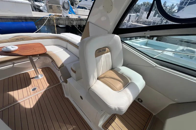 Slide: The Image of 2005 Sea Ray Sundancer 350 interior with cushioned seating and wooden table. - 23
