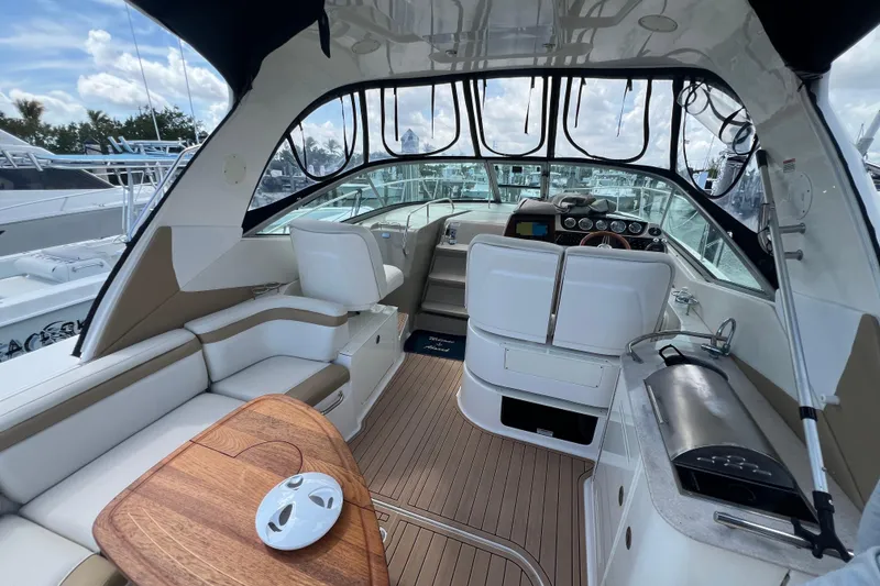 Slide: The Image of 2005 Sea Ray Sundancer 350 interior with seating, helm, and wooden table. - 7