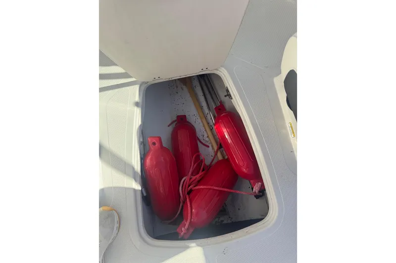 Slide: The Image of Storage compartment in 2016 Tahoe 500 TF boat with red fenders and ropes. - 13