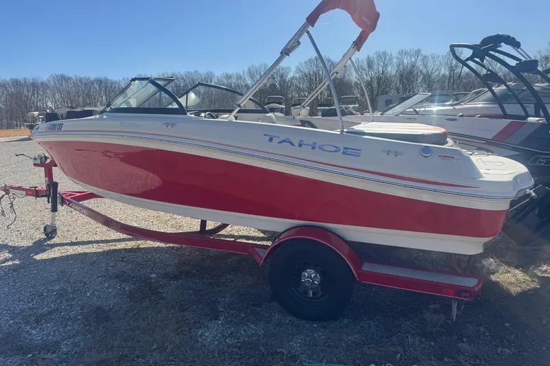 Slide: The Image of 2016 Tahoe 500 TF red and white boat on trailer, parked outdoors. - 2