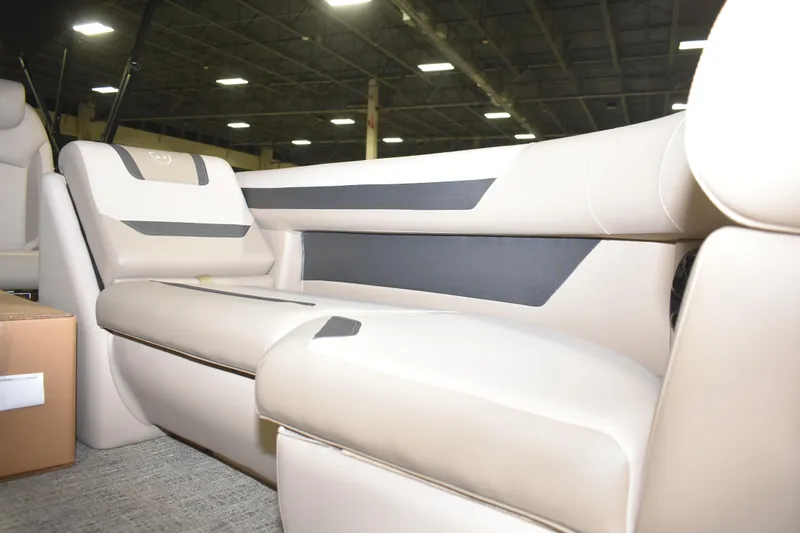 Slide: The Image of 2026 Premier 220 Sunscape RF - CL boat interior with beige seating in a showroom. - 10