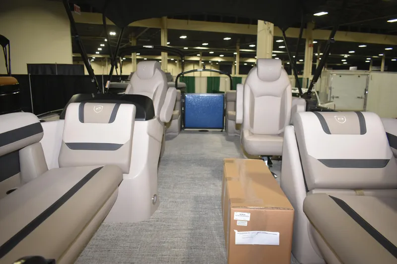 Slide: The Image of 2026 Premier 220 Sunscape RF - CL boat interior with beige seating and a cardboard box. - 6