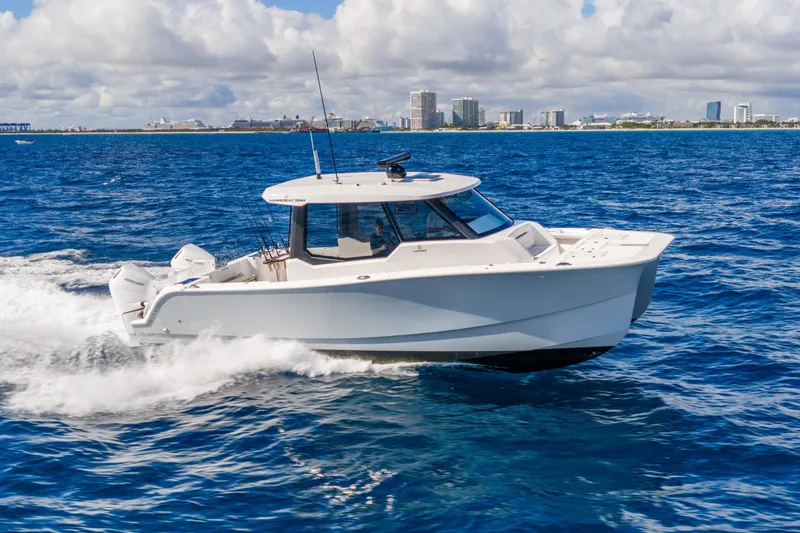 Slide: The Image of 2026 Hammer Yachts 35HH cruising on blue ocean near city skyline. - 2