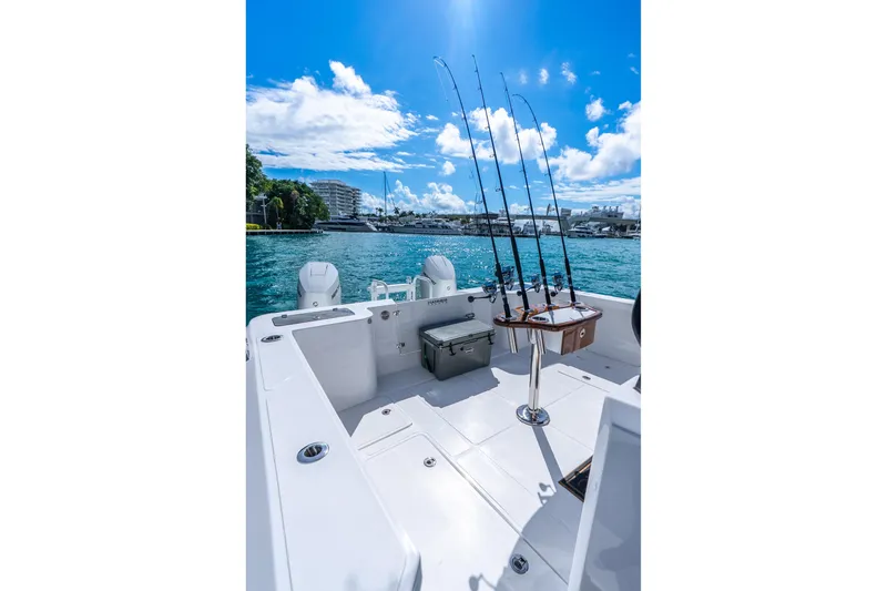 Slide: The Image of 2026 Hammer Yachts 35HH boat with fishing rods, docked in a scenic marina. - 32