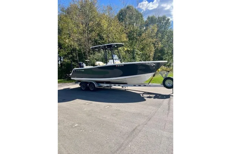 The Image of 2023 Sportsman Open 232 Center Console boat on trailer, parked outdoors. - 3