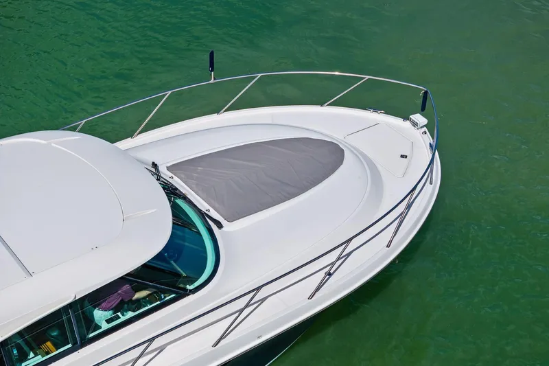 Slide: The Image of 2018 Tiara Yachts C44 Coupe on green water, showcasing sleek design and spacious deck. - 12