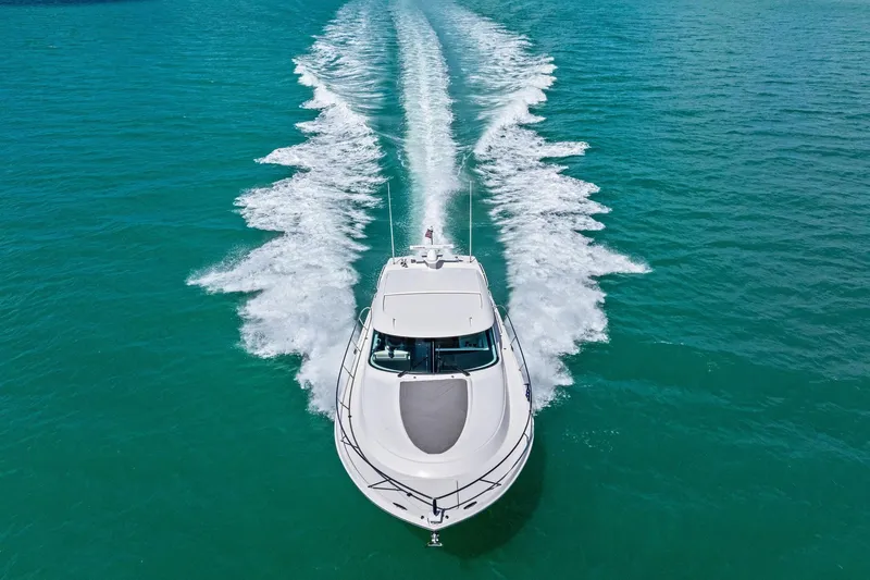 Slide: The Image of 2018 Tiara Yachts C44 Coupe cruising on turquoise water, aerial view. - 15
