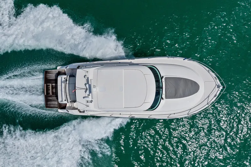 Slide: The Image of Aerial view of 2018 Tiara Yachts C44 Coupe cruising on turquoise water. - 24