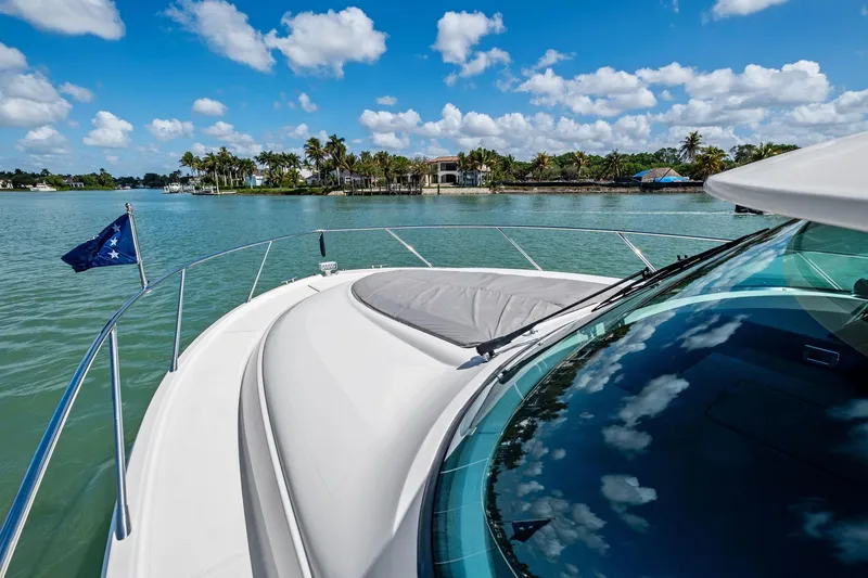 Slide: The Image of 2018 Tiara Yachts C44 Coupe cruising on a sunny day with palm trees in the background. - 26