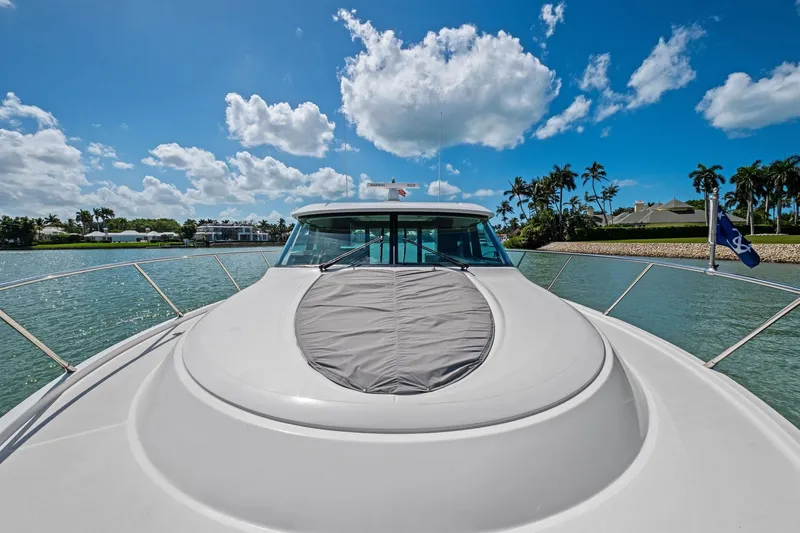 Slide: The Image of 2018 Tiara Yachts C44 Coupe on serene water, under a bright blue sky. - 27