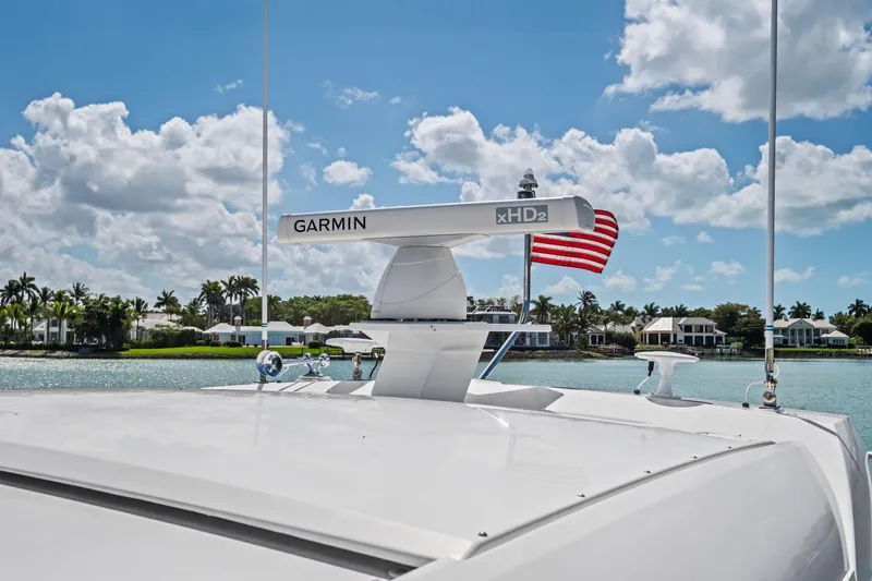 Slide: The Image of 2018 Tiara Yachts C44 Coupe with Garmin radar, American flag, and scenic waterfront view. - 30