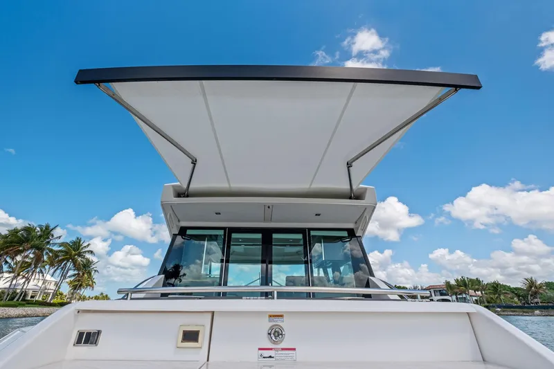 Slide: The Image of 2018 Tiara Yachts C44 Coupe with extended sunshade, under clear blue sky. - 39