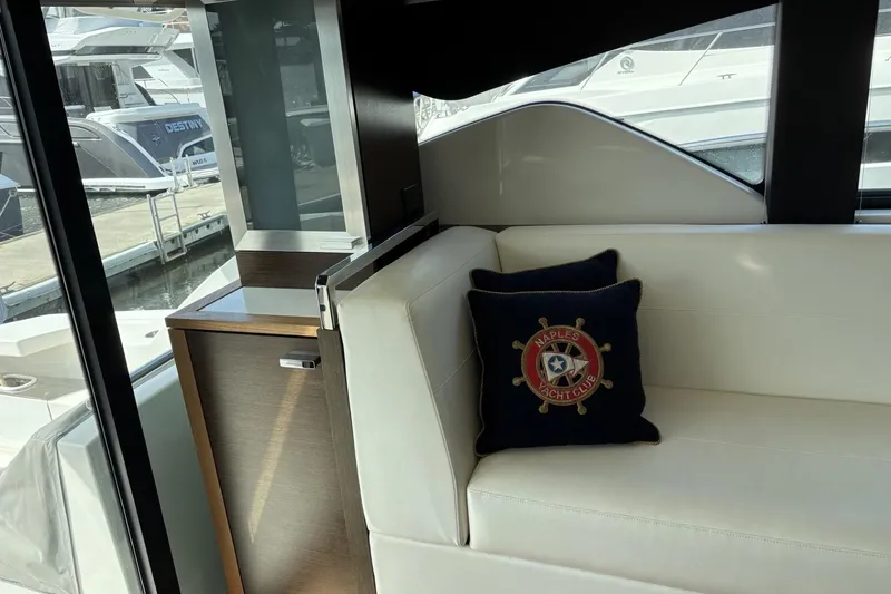 Slide: The Image of Interior of 2018 Tiara Yachts C44 Coupe with white seating and nautical-themed pillow. - 4