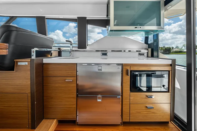 Slide: The Image of 2018 Tiara Yachts C44 Coupe interior kitchen with modern appliances and wood cabinetry. - 43