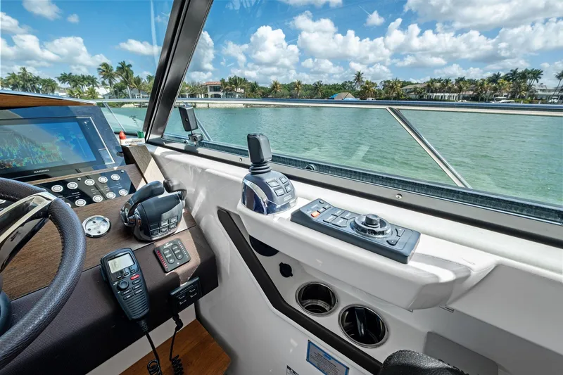 Slide: The Image of Cockpit view of 2018 Tiara Yachts C44 Coupe with navigation controls and scenic waterway. - 52