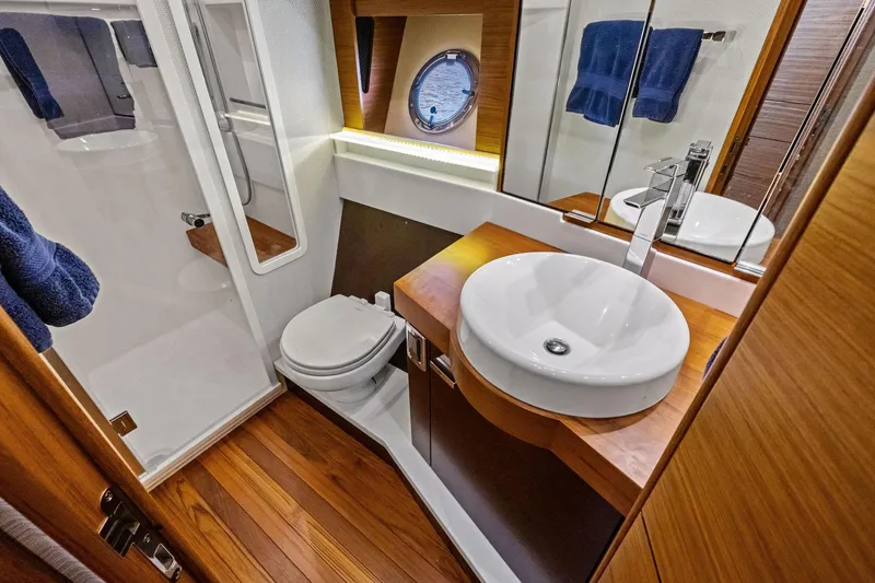 Slide: The Image of Luxurious bathroom in 2018 Tiara Yachts C44 Coupe with modern fixtures and wooden accents. - 61