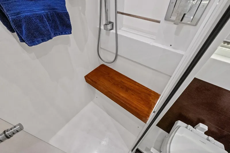 Slide: The Image of 2018 Tiara Yachts C44 Coupe bathroom with wooden shower bench and blue towel. - 63